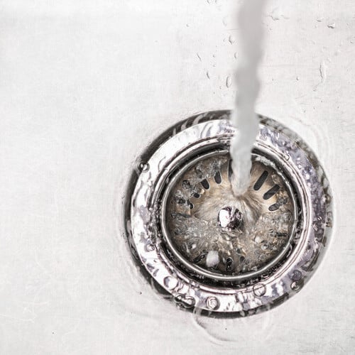 Water flowing down the hole in a kitchen sink