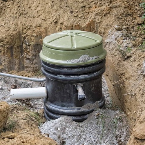 grinder pump sitting in a ditch