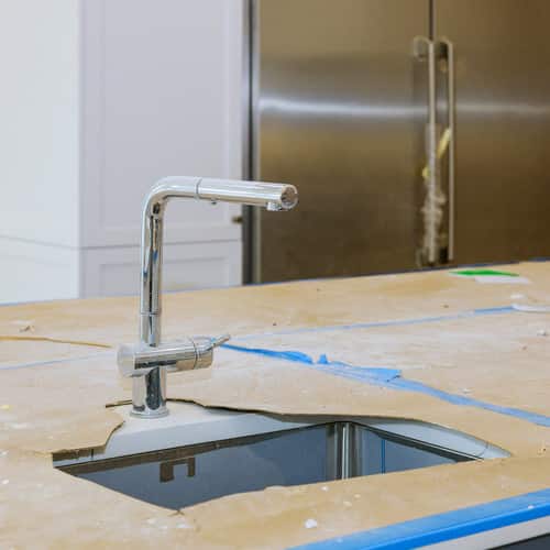 Close up of sinks in modern white kitchen with in designed luxury apartment
