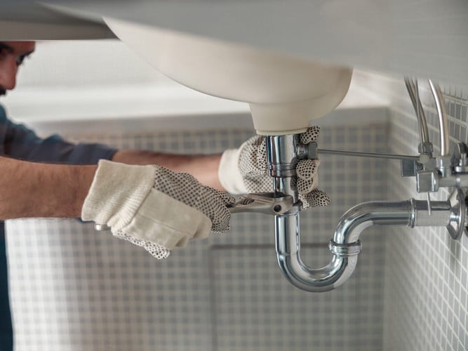 plumber repairing a leaking pipe